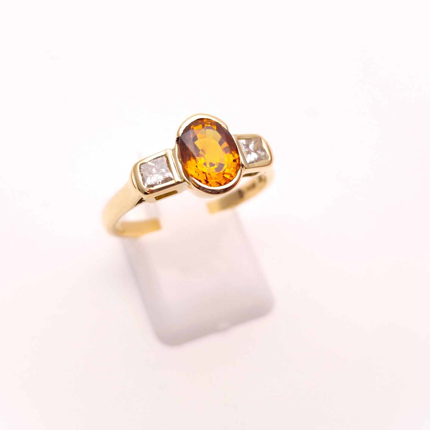 18ct Yellow Gold Oval Cut Orange Sapphire and Princess Cut Diamond Trilogy Ring