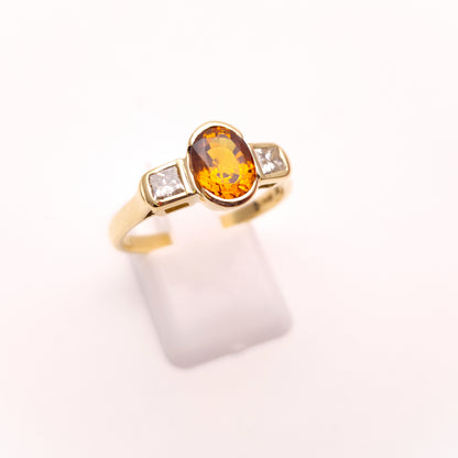 18ct Yellow Gold Oval Cut Orange Sapphire and Princess Cut Diamond Trilogy Ring