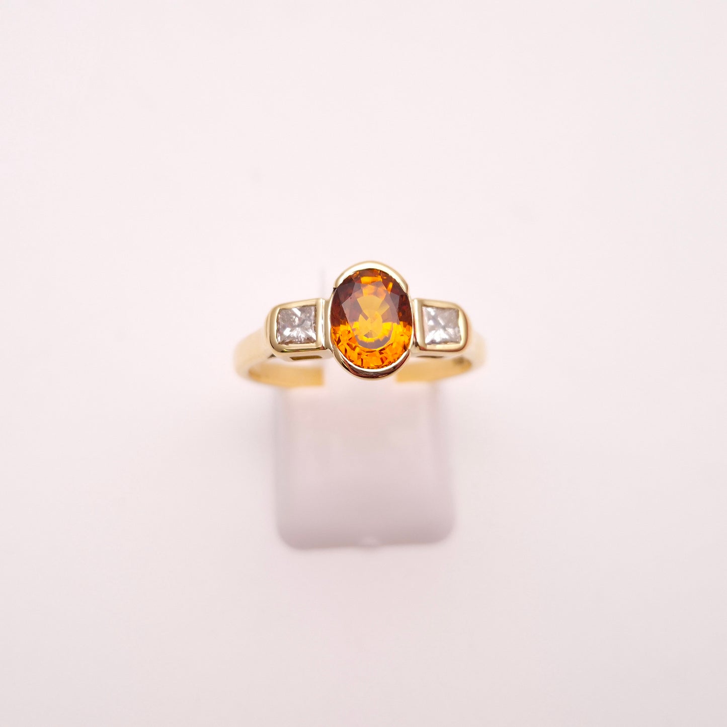18ct Yellow Gold Oval Cut Orange Sapphire and Princess Cut Diamond Trilogy Ring