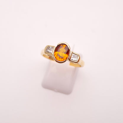 18ct Yellow Gold Oval Cut Orange Sapphire and Princess Cut Diamond Trilogy Ring