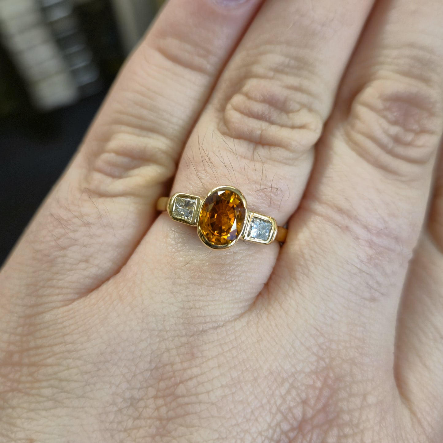 18ct Yellow Gold Oval Cut Orange Sapphire and Princess Cut Diamond Trilogy Ring