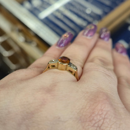 18ct Yellow Gold Oval Cut Orange Sapphire and Princess Cut Diamond Trilogy Ring