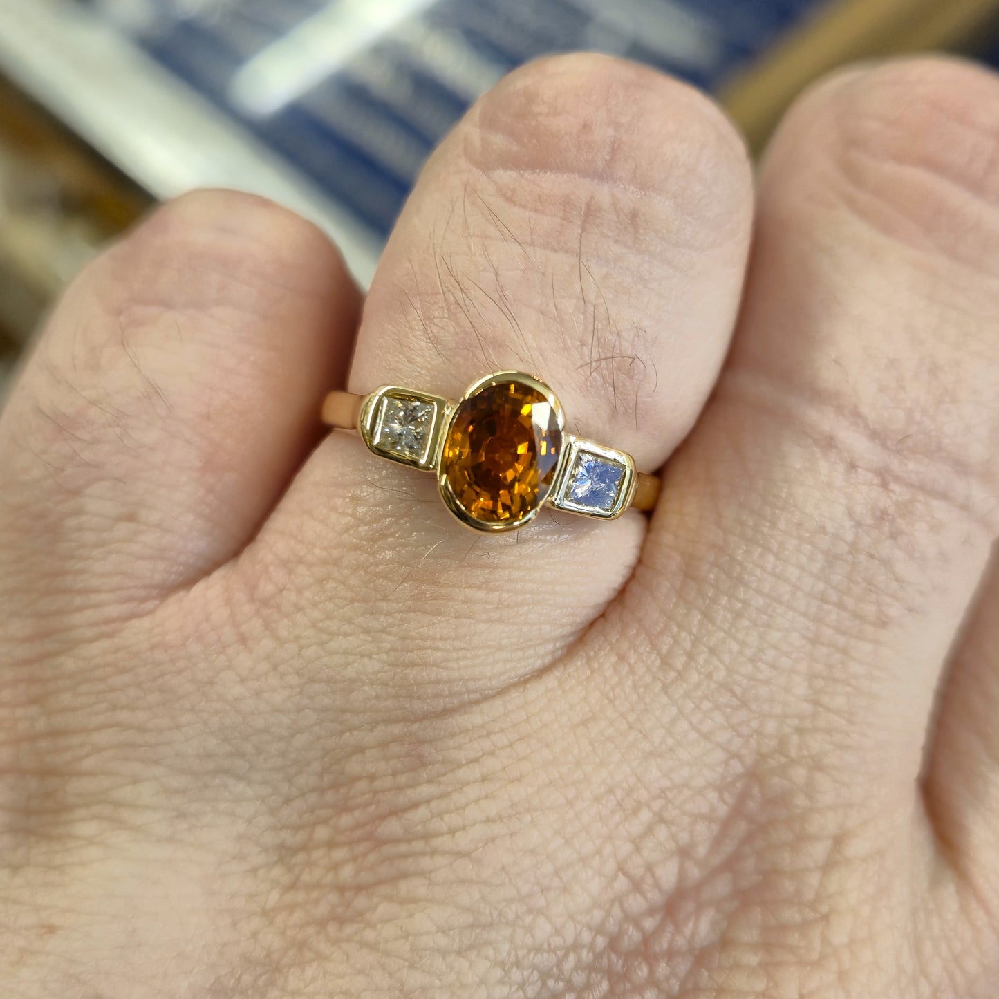 18ct Yellow Gold Oval Cut Orange Sapphire and Princess Cut Diamond Trilogy Ring